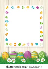Happy Easter greeting Card, painted eggs in grass, white board with copy space, wood background