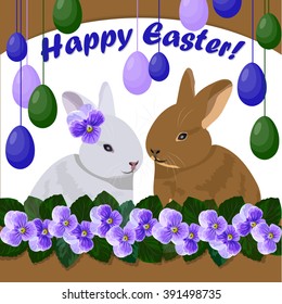 Happy Easter greeting card. Two cute rabbits sitting among the violet flowers. Colored eggs hanging on strings.