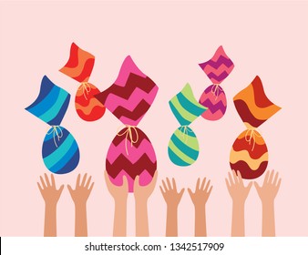 Happy Easter holiday. kids hands catching Easter eggs in air. Chocolate wrapped in colorful pattern.