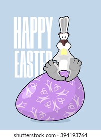 Happy Easter. Rabbit and egg. Traditional treats. Funny Bunny sitting on Colored eggs. Symbol of holiday