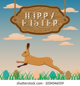 Happy easter. Wooden signboard against the background of the evening sky. In the grass eggs. The Hare Jumps