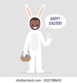 Happy easter. Young character wearing a white bunny costume and holding a basket with dyed eggs. Holidays. Flat editable vector illustration, clip art. Culture and celebrations.