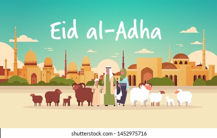 happy Eid al-Adha mubarak muslim holiday concept arab family standing with white and black flock of sheep festival of Sacrifice nabawi mosque building cityscape flat full length horizontal