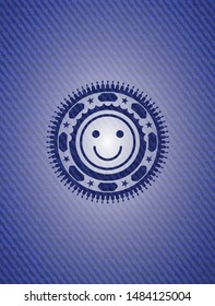 happy face icon inside badge with denim background