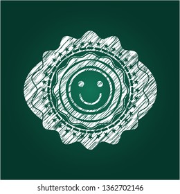 happy face icon inside chalkboard emblem written on a blackboard