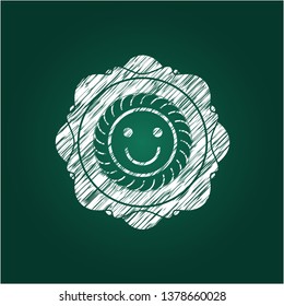 happy face icon inside chalkboard emblem written on a blackboard