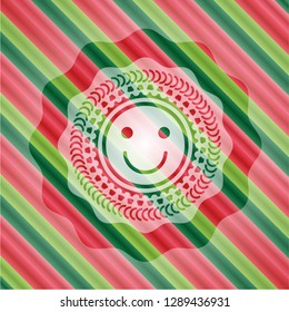 happy face icon inside christmas colors emblem.