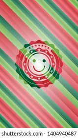 happy face icon inside christmas colors emblem.