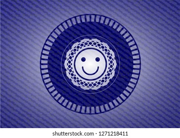 happy face icon inside emblem with denim texture
