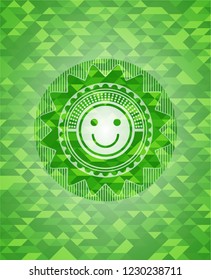 happy face icon inside green emblem with mosaic background
