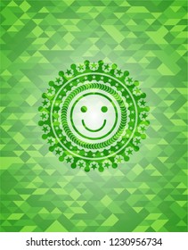 happy face icon inside green mosaic emblem