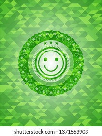 happy face icon inside green mosaic emblem