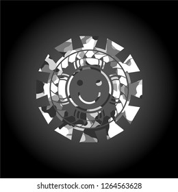 happy face icon inside grey camouflage emblem