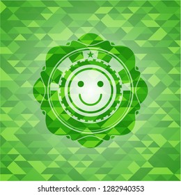 happy face icon inside realistic green mosaic emblem