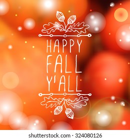 Happy Fall Y'all. Hand-sketched typographic element with acorns on blurred background. 