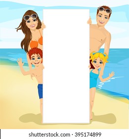 happy family behind a white blank billboard at the beach
