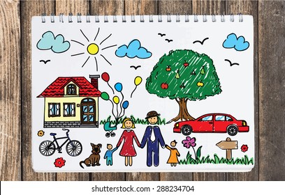 Happy Family Concept. Colorful Drawing Of A Family On Top Of The Notebook. Home, Car, Bicycle, Tree, Grass, Flowers, Dog, Clouds, Sun, Birds. Top View.