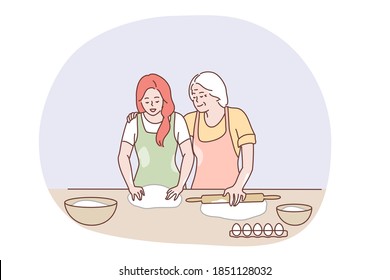 Happy family cooking together concept. Happy elderly grandmother hugging granddaughter and showing how to bake pastry or pie with eggs and dough in kitchen. Baking, family, grandparents help