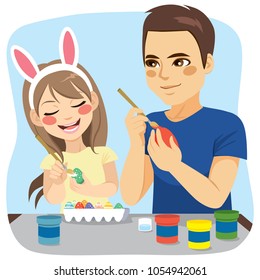 Happy family of father and daughter painting easter eggs 