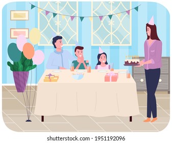 Happy family at festive table with gifts and birthday cake. Room is decorated with garland and balls