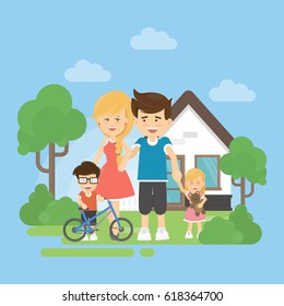 Happy Family With House. Parents With Son And Dauhter Stands Near The Home. Boy With Bycicle.