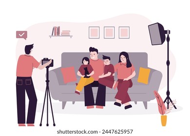 Happy family portrait, people sitting on the sofa and photographer taking photos. Father, mother, son and daughter together before camera. Parents and children in photo studio interior with equipment.