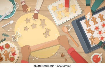 Happy family preparing sweets for Christmas: the mother is flattening the dought with a rolling pin and the kids are helping her