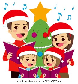 Happy family singing carols in front of Christmas tree at home