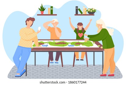 Happy family sitting at table and playing board game. Parents and children spending evening time together. Guy standing with cards in his hands. Girl points to the man. Kids joyfully raise hands