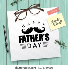 Happy fathers day greeting card with typography design, note paper, pen and glasses on wooden texture background