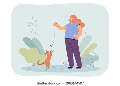 Happy girl playing with cat with bow flat vector illustration. Teenager standing on lawn, having fun with pet. Entertainment, animal companion concept for banner, website design or landing web page
