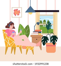 Happy girl sitting in chair in cozy room and listening to music on headphones. Interior of the room with flowers, window, chair