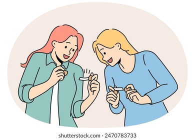 Happy girls hold fortune cookies and laugh as rejoice at cheerful wishes found inside pastry. Young women in casual clothes are intrigued reading messages hidden in cookies with wishes.