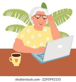 Happy grandma with laptop.An elderly woman uses a computer while sitting at a table with a cup of tea.Character with glasses.White background with a plant.Vector cartoon flat style illustration.