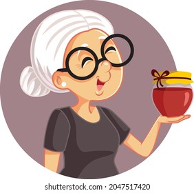 Happy Granny with a Jar of Homemade Jam Vector Cartoon
Grandmother holding her special marmalade can
