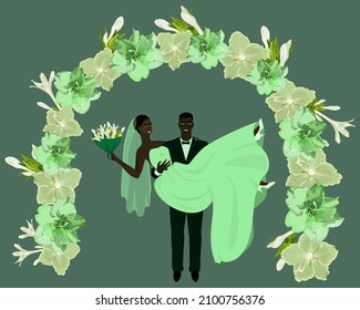 Happy groom holding the bride in his arms under the flower arch