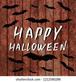 Happy Halloween hand written with brush and flying bats on wooden background. Grunge style lettering. White gouache drawing. Easy to edit template for Halloween party banner or greeting card.
