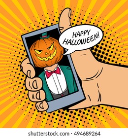 Happy Halloween! Male hand holding a smartphone with a man in a suit with pumpkin jack-o-lantern head on screen.Vector illustration in retro comic style. Colorful pop art background. Party invitation.
