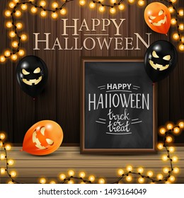 Happy Halloween, square greeting banner with chalk board with beautiful lettering, wood wall and Halloween balloons