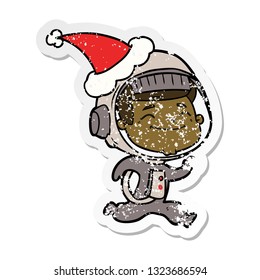 happy hand drawn distressed sticker cartoon of a astronaut wearing santa hat