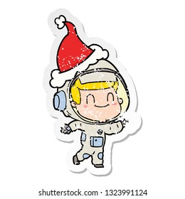 happy hand drawn distressed sticker cartoon of a astronaut man wearing santa hat
