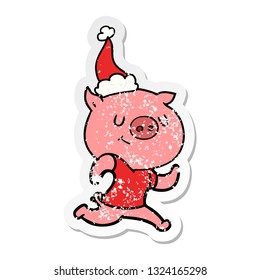 happy hand drawn distressed sticker cartoon of a pig running wearing santa hat