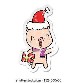 happy hand drawn distressed sticker cartoon of a pig with xmas present wearing santa hat