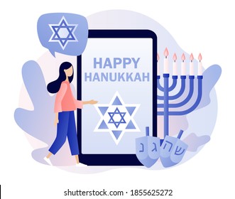 Feliz Hanukkah - texto en la pantalla del smartphone. Fiesta judía tradicional con gente pequeña y símbolos - velas de menorah, sueños girando arriba, estrella David. Estilo moderno de dibujos animados planos. Ilustración del vector