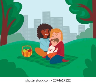 Happy homosexual family having a picnic outdoors together. Lesbian mothers sit on the mat and hug their baby. Adoption, LGBT parents.