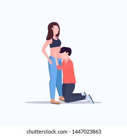 happy husband on knee listening his pregnant wife's belly cheerful couple man woman waiting newborn baby pregnancy parenthood concept full length