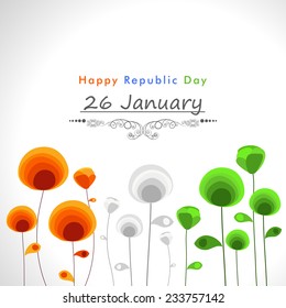 Happy Indian Republic Day celebration concept with beautiful text and flowers in national flag colors on shiny grey background.