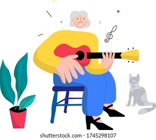Happy joyful older woman playing ukulele instrument. Person enjoys her hobby with cat by her side.
