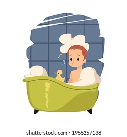 Happy kid boy washes in bath with water and soap foam in home bathroom