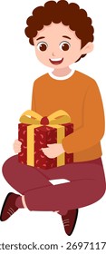 Niño feliz sentado con regalo envuelto